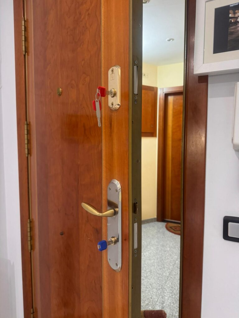 Puerta de madera con dos bombines nuevos, manilla y llaves entregadas al cliente